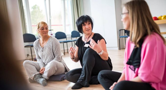 Eine Gruppe sitzt auf dem Boden und macht Entspannungsübungen