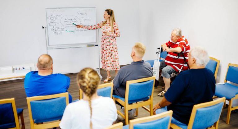 Mitarbeiterinnen erläutern einer Gruppe die Faktoren, die das Gewicht beeinflussen. 