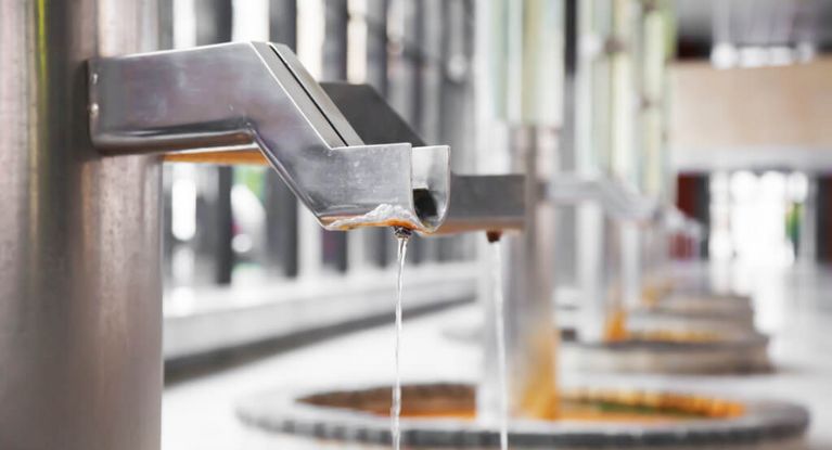 Heilwasser fließt aus einem Trinkhahn