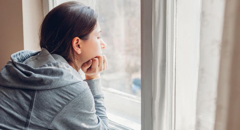 Traurige Frau schaut aus dem Fenster