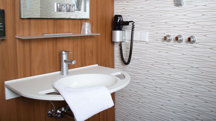 Privita Badezimmer mit einem Waschbecken und Föhn an der Wand