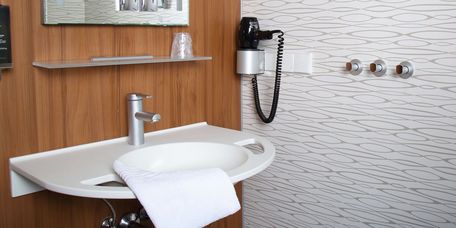 Privita Badezimmer mit einem Waschbecken und Föhn an der Wand