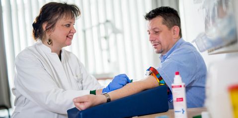 Die Ärztin nimmt einem Patienten Blut ab
