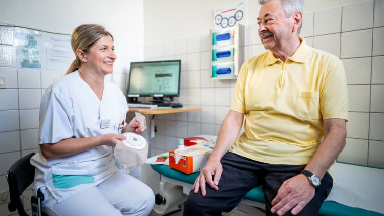 Pflegekraft erklärt Patienten, wie man ein Stoma benutzt
