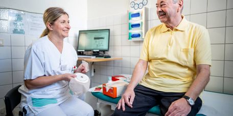Pflegekraft erklärt Patienten, wie man ein Stoma benutzt