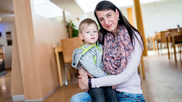 Mutter hält ihr Kind im Arm