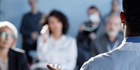 Arzt hält Vortrag vor einem gemischten Publikum