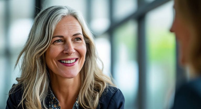 Eine Frau lacht und führt dabei ein Gespräch