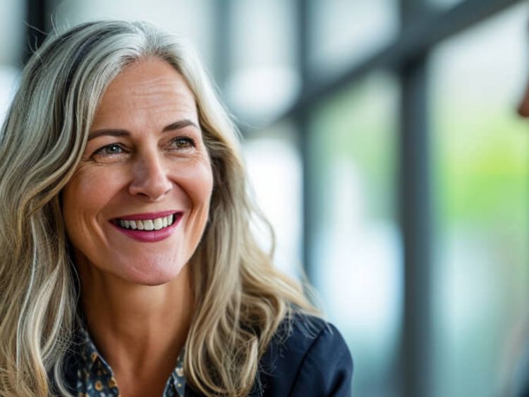 Eine Frau lacht und führt dabei ein Gespräch
